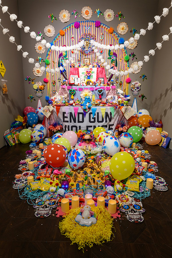Colorful Mex stile altar installation against Gun Violence: Ofrenda - altar. Image courtesy of Rowan University Art Gallery and Museum, photo credit: Constance Mensh